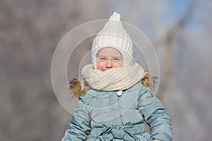 Portrait of little girl in warm wear walks in winter