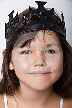 Portrait of little girl wearing black crown