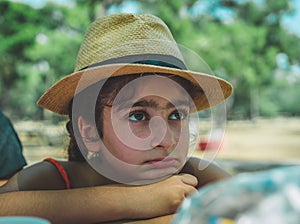 Portrait of a little girl wearing a hat outdoors