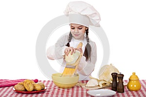 Portrait of a little girl in a white apron and chefs hat shred c