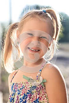 Portrait of a little girl with a wobbly baby tooth