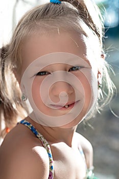 Portrait of a little girl with a wobbly baby tooth