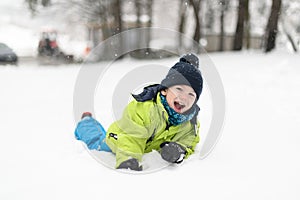 Portrait of Little Happy Boy Lies in Snow