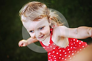 Portrait of a little happy girl. the child holds the hand of the parent and plays