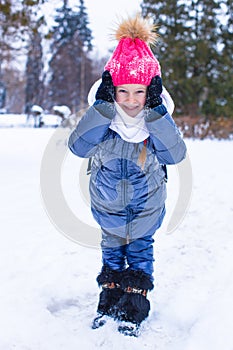 Portrait of little happy girl in the snow sunny