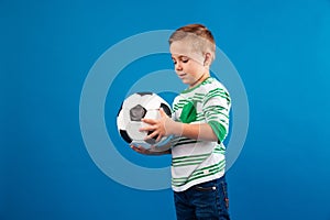 Portrait of a little kid looking and holding soccer ball