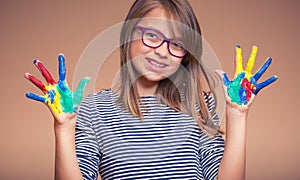 Portrait of a little pre-teen student girl showing painted hands. Toned Photo