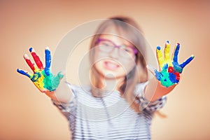 Portrait of a little pre-teen student girl showing painted hands. Toned Photo