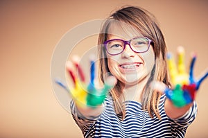 Portrait of a little pre-teen student girl showing painted hands. Toned Photo