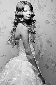 Portrait of a little princess in white vapory classic dress with pearls posing over vintage background. Girl with perfect glossy