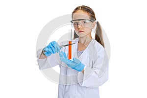 Portrait of little school girl, kid in white big gown as chemist, scientist doing experiment with multicolored chemical