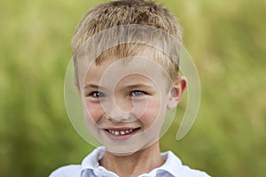 Portrait of a little smiling boy with golden blonde straw hair i