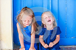 Portrait of Little smiling girls sitting near old