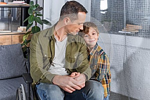 portrait of little son and father in wheelchair