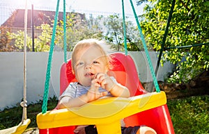 Portrait of little toddler swing in the backyard