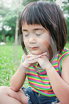 Portrait of little young asian girl praying