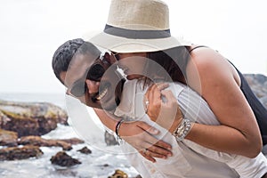 Portrait of living young couple at the beach. They are happy and smile. Concept of just married family