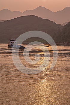 Portrait of loaded barge while sunset reflected by Yangtze River, Chongqing, China