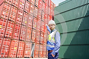 Portrait of Logistic engineer worker man standing in shipping container yard and crossed arms. Confident engineering work at