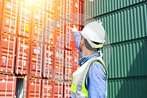 Portrait of Logistic engineer worker man standing in shipping container yard and crossed arms. Confident engineering work at