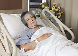 Lonely Asian senior  woman lying in hospital bed, looking up and thinking. Elderly health concept