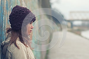 Portrait of lonely teenage girl on moody winter day