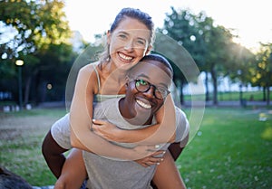 Portrait, love and piggyback with an interracial couple together outdoor in a park for bonding or a date. Summer