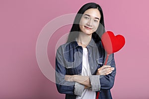 Portrait of lovely asia woman embracing heart isolated on pink background , Red heart symbol of Valentines day smiling asian woman