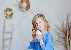 Portrait of lovely, cheerful blond girl , holding colored eggs, celebrating Easter with family