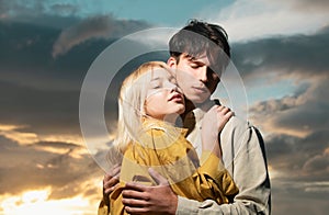 Portrait of lovely couple in love on sunset. Young sensual girlfriend glad to passionate kiss from her boyfriend