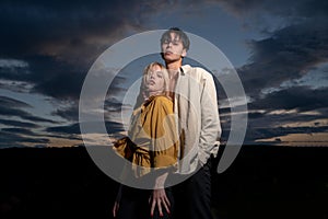 Portrait of lovely couple in love. Young sensual girlfriend glad to passionate kiss from her boyfriend on dramatic sky