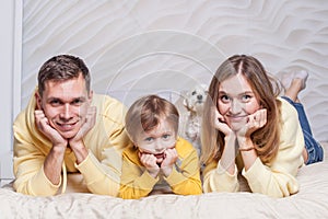 Portrait of lovely family, friendly parents, mom and dad with adorable child son and white dog