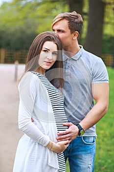 Portrait of lovely future parents in sunny day in park in sunny day