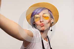 Portrait of lovely glamour hipster girl taking selfie, looking at camera POV. isolated on white background, studio shot