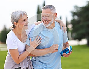 Portrait of lovely happy elderly couple on morning run outside in city park