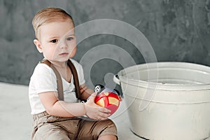 Portrait of lovely little boy happy smiling celebrating 1 year birthday. One year old european boy sitting on floor