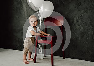 Portrait of lovely little boy happy smiling celebrating 1 year birthday. One year old european boy sitting on floor