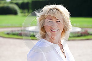 Portrait of lovely middle aged woman in the summer park