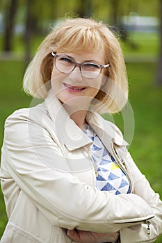 portrait of lovely middle aged woman in the summer park