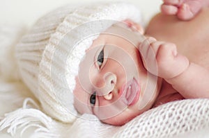 Portrait of lovely newborn in white knitted hat