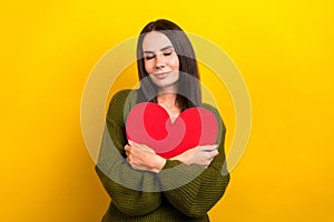 Portrait of lovely peaceful girl closed eyes hands hold hug red paper heart isolated on yellow color background