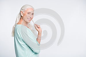 Portrait of lovely person touching her hair looking smiling at camera wearing teal pullover isolated over white