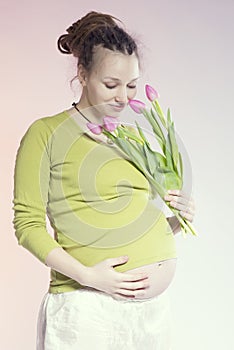 Portrait of lovely pregnant woman with tulips
