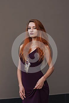 Portrait of lovely slim redhead girl in wine dress and dreamcatcher craft talisman