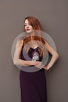 Portrait of lovely slim redhead girl in wine dress and dreamcatcher craft talisman