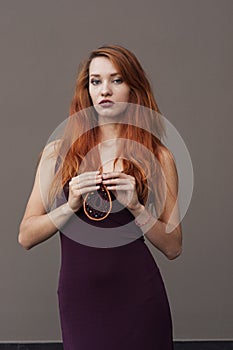 Portrait of lovely slim redhead girl in wine dress and dreamcatcher craft talisman