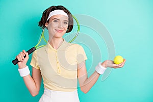 Portrait of lovely sportive cheery girl holding in hand racket tennis ball isolated over bright teal turquoise color