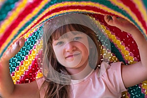 Portrait of lovely toddler girl playing under blanket. Lifetime moments and happy childhood concept