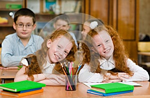 Portrait of lovely twins girls with schoolboys on background. lo photo