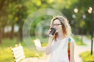 Portrait of lovely urban girl with paper cup in her hands